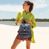 Mochila de nylon color bordó con tapa y broche metálico. Tiene apertura superior con broche, bolsillos internos, bolsillo con cierre metálico al frente y laterales. Incluye asas rígidas de mano y correas regulables para colgar en la espalda.