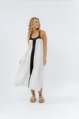 Vestido largo blanco con panel negro vertical en el frente, corte amplio, escote recto y tiras anchas.