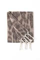 Bufanda de textura suave con estampado animal print en tonos beige y marrón, terminada con flecos trenzados en los extremos.