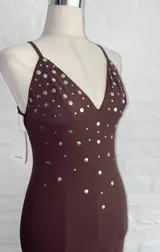 Vestido largo marrón con escote halter y espalda descubierta, con apliques de strass plateados en el corpiño.