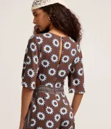 Mono largo de viscosa con estampado gráfico de soles, escote en V profundo, mangas cortas amplias y aberturas laterales en la cintura.