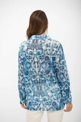 Camisa de manga larga con cuello clásico y cierre frontal de botones, confeccionada en tela liviana con estampado tipo tie-dye en tonos celestes y blancos.