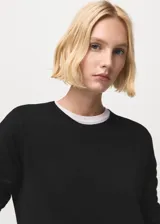 Jersey de punto fino color negro, con cuello redondo y manga larga, de diseño recto.