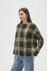 Sweater de punto jacquard con diseño a cuadros en tonos beige y bordó, de corte holgado, cuello redondo y mangas largas.