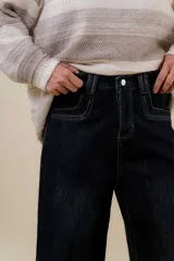 Jean wide leg de tiro alto con calce relajado y pierna amplia. Confeccionado en denim con leve desgaste, cuenta con cintura definida con presillas, bolsillos clásicos y cierre frontal con botón metálico.