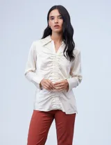 Blusa color beige de satén con cuello con solapa, escote en V y frunces en la parte delantera.