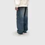 Pantalón de jean estilo cargo con corte ultra baggy, de tiro medio y pernera ancha. Presenta bolsillos laterales tipo cargo y un lavado de efecto desgastado.