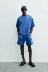 Sudadera de manga corta color marrón oscuro, con cuello redondo y bajo acabado en rib. Presenta un corte relajado y holgado (boxy fit).