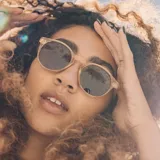 Lentes de sol Sunski modelo Dipsea, con montura redonda color rosa pálido y lentes polarizadas color marrón.