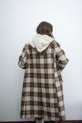 Chaqueta de corte sastre con estampado de cuadros en tonos marrones y beige, con solapas clásicas y cierre frontal con botones.