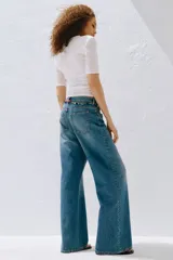 Jean de tiro alto y corte baggy, confeccionado en denim de algodón rígido en color celeste con efecto deslavado. Presenta diseño de cinco bolsillos, piernas rectas y holgadas, y cierre frontal con botón y cremallera.