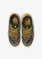 Championes urbanos Satorisan modelo Chacrona, confeccionados en cuero marrón con detalles en gamuza, cordones amarillos y suela de goma con efecto salpicado y detalles en verde.