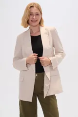 Blazer color beige de lino, con cuello solapa, corte holgado y bolsillos laterales.