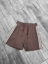 Short deportivo color moka con cintura elástica ajustable con cordón y dos líneas verticales blancas a los costados.