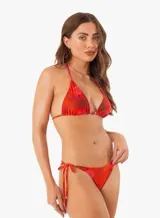 Conjunto de bikini con estampado de corales rojos. El corpiño es de triángulo con tirantes finos y la bombacha se ata a los costados.