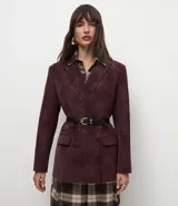 Blazer estructurado de corte sastre confeccionado en tejido sintético tipo gamuza (suede), con diseño de abotonado cruzado, solapas clásicas, bolsillos con tapa y mangas largas con botones en los puños.