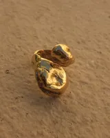 Anillo de diseño abierto con formas orgánicas e irregulares, con acabado brillante y textura rugosa.