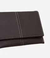 Billetera sobre de tamaño pequeño confeccionada en poliuretano color marrón oscuro, con detalle de pespuntes en hilo blanco y cierre mediante botón a presión.
