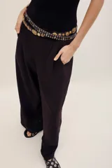 Pantalón ancho negro de tiro medio, con bolsillos laterales y pinzas frontales.