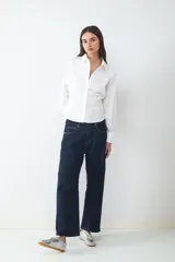 Jeans de tiro medio con corte barrel y ajuste relajado, diseño clásico de cinco bolsillos, cierre frontal de cremallera y botón metálico.