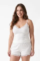 Conjunto de pijama de dos piezas de tejido rib color blanco, compuesto por una musculosa de tirantes finos con detalle de encaje en el escote y un short con detalles de encaje en el ruedo.