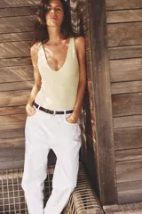 Body negro de tejido texturizado, con escote en V pronunciado y tirantes anchos.