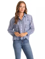 Camisa de algodón color gris con bordados florales en el frente y las mangas. Tiene cuello con solapa y cierre frontal con botones.