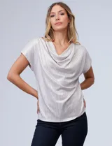 Blusa de mujer Cable & Gauge color beige claro, confeccionada en tejido lurex con textura plisada vertical. Presenta un escote drapeado tipo cuello volcado y mangas cortas.