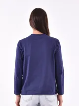 Remera de manga larga color beige, con cuello redondo y estampado frontal que dice "Magic is something you make" en color lila.