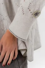 Saco tejido de lambswool color marrón, con diseño inspirado en kimono, mangas largas y delicados calados en toda la prenda. Cuenta con bordes en contraste.