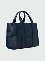 Cartera tipo tote de Marc Jacobs, confeccionada en cuero granulado color azul marino. Presenta el logo de la marca estampado en el frente, doble asa superior y correa ajustable y extraíble para llevar al hombro o cruzada.