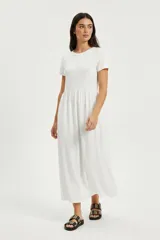 Vestido midi de corte holgado, con mangas cortas y cintura elástica. Presenta un diseño sencillo y fluido, ideal para un look casual y cómodo.
