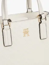 Cartera tote de poliuretano color blanco con acabado texturizado y motivo integral del monograma TH en bajo relieve. Cuenta con dos asas superiores, correa cruzada extraíble y detalles metálicos dorados, incluyendo el monograma TH en la parte delantera.