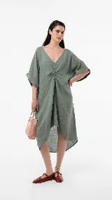 Vestido midi de lino color verde militar, con escote en V, detalle fruncido en el centro del frente y mangas cortas amplias. Posee una silueta relajada y asimétrica.