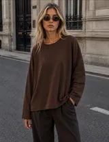 Buzo oversize de cuello redondo y manga larga, confeccionado en tejido de punto liso color marrón chocolate.