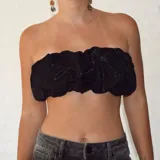 Top bandeau negro con textura fruncida y estampado abstracto plateado.