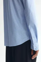 Camisa H&M de corte slim fit en mezcla de algodón con rayas finas celestes y blancas. Presenta cuello italiano, cierre frontal con botones y mangas largas.