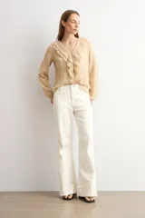 Pantalón de jean wide leg en color blanco, de tiro alto y corte ancho con dobladillo ancho en los bajos.