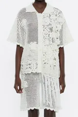 Camisa de crochet color blanco, con cuello camisero, manga corta y cierre frontal con botones.