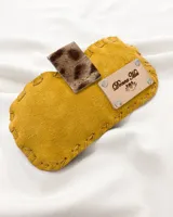 Funda para lentes de cuero color mostaza con apliques de cuero con estampado animal print y etiqueta de cuero con logo grabado.