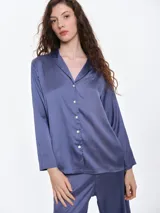 Camisa de dormir de satén con cuello solapa, cierre frontal con botones y mangas largas. Presenta un corte holgado y fluido.