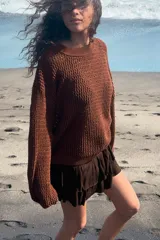 Jersey de punto color marrón con diseño calado semitransparente, cuello redondo y mangas largas con terminaciones en rib.