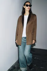 Blazer oversize de Zara Woman Collection confeccionado en mezcla de lana, con cuello sin solapa, manga larga y cierre frontal con botón. Presenta bolsillos delanteros con solapa.