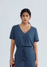 Blusa naranja de lino con escote en V y mangas cortas.