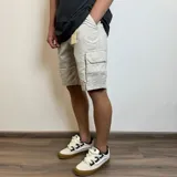 Bermuda cargo de gabardina en color beige, con bolsillos laterales tipo cargo con solapa y cierre de botón.