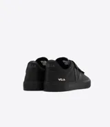 Championes Veja modelo Recife, color negro, confeccionados en cuero ChromeFree, con logo "V" de caucho en los laterales y ajuste con tres tiras de velcro.