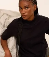 Remera negra de algodón, corte amplio, cuello alto en punto roma y mangas cortas.