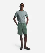 Bermuda masculina de corte recto, confeccionada en sarga de algodón, con bolsillos laterales y traseros, cierre de botón y cremallera.