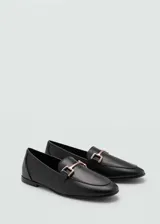 Mocasines planos de mujer confeccionados en piel bovina color negro, con punta redonda y detalle metálico dorado en el empeine.