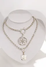 Collar de cadena de eslabones gruesos con dije circular de diseño geométrico tipo mandala, con cierre frontal de argolla.